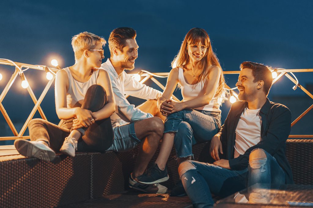 Group of friends enjoying evening lights and rooftop vibes, one of the fun things to do in Cracow at night.